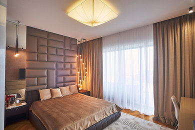 Imagen de dormitorio principal actual de tamaño medio con paredes marrones, suelo de madera clara y suelo amarillo