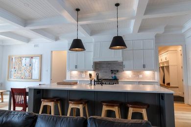 Example of a mid-sized cottage galley medium tone wood floor and coffered ceiling open concept kitchen design in Other with a farmhouse sink, shaker cabinets, white cabinets, quartz countertops, stainless steel appliances, an island and white countertops
