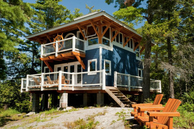 Mid-sized beach style blue two-story vinyl flat roof photo in Boston