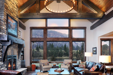 Inspiration for a rustic open concept dark wood floor and brown floor living room remodel in Other with white walls, a standard fireplace and a stone fireplace