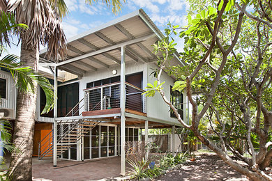 Medium sized world-inspired front veranda in Darwin with brick paving and a roof extension.