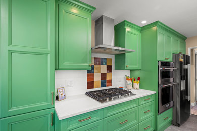 Example of a mid-sized eclectic galley eat-in kitchen design in Other with recessed-panel cabinets, green cabinets, quartz countertops, multicolored backsplash, ceramic backsplash, stainless steel appliances, no island and white countertops