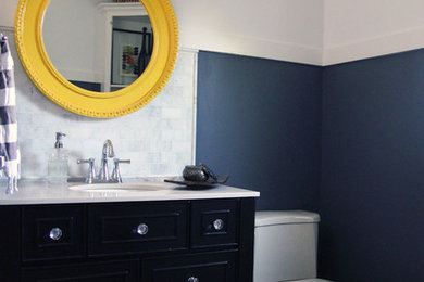Powder room - small modern white tile and subway tile medium tone wood floor powder room idea in Omaha with an undermount sink, dark wood cabinets, marble countertops, a two-piece toilet and gray walls
