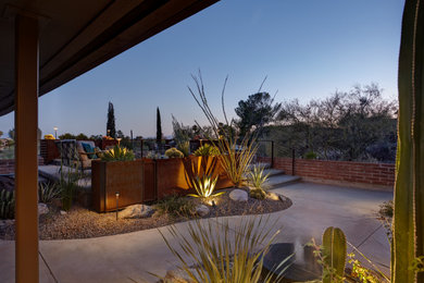 Design ideas for a small mid-century modern drought-tolerant and full sun front yard concrete paver and metal fence landscaping in Phoenix for winter.