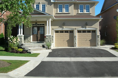 Photo of a mid-sized transitional full sun front yard concrete paver driveway in Toronto.