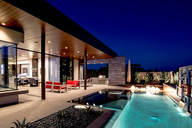 Mid-sized trendy backyard concrete patio photo in Las Vegas with a fire pit and a roof extension
