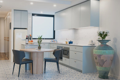 Design ideas for a small beach style l-shaped eat-in kitchen in Melbourne with recessed-panel cabinets, quartz benchtops, engineered quartz splashback, ceramic floors and with island.