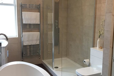 Ispirazione per una stanza da bagno per bambini minimal di medie dimensioni con vasca freestanding, doccia aperta, piastrelle beige, pavimento in laminato, lavabo sospeso, pavimento marrone e doccia aperta