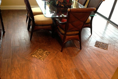 Wood flooring with transition of river rock to kitchen wood grain porcelain.