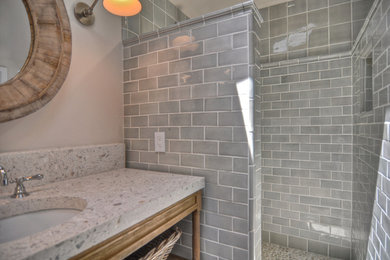 Inspiration for a transitional bathroom in Orange County with an undermount sink, open cabinets, distressed cabinets, concrete benchtops, an open shower, gray tile, subway tile and grey walls.