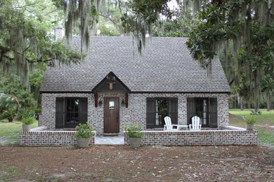 Mid-sized country one-storey brick house exterior in Jacksonville with a gable roof and a shingle roof.