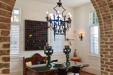 Inspiration for a mid-sized southwestern medium tone wood floor and brown floor enclosed dining room remodel in Atlanta with white walls and no fireplace