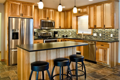 Eat-in kitchen - mid-sized traditional l-shaped vinyl floor eat-in kitchen idea in Minneapolis with an undermount sink, recessed-panel cabinets, light wood cabinets, granite countertops, multicolored backsplash, glass tile backsplash, stainless steel appliances and an island