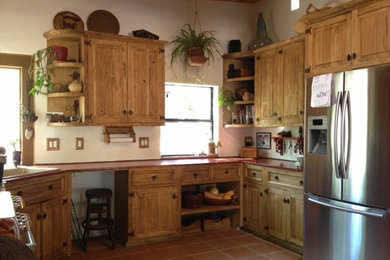 Example of a mountain style kitchen design in Other with distressed cabinets