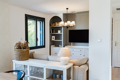 Ejemplo de sala de estar abierta tradicional grande con paredes blancas, suelo de madera clara, televisor colgado en la pared, suelo beige y papel pintado