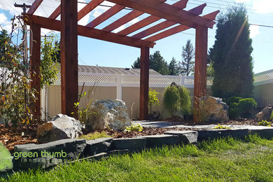 Photo of a rustic full sun backyard stone retaining wall landscape in Edmonton for summer.
