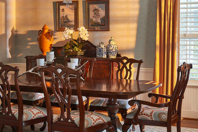 Example of a large transitional medium tone wood floor enclosed dining room design in Orlando with blue walls and no fireplace