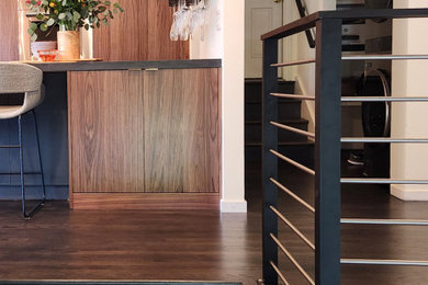 Inspiration for a large 1950s l-shaped dark wood floor and brown floor eat-in kitchen remodel in San Francisco with an undermount sink, flat-panel cabinets, medium tone wood cabinets, laminate countertops, white backsplash, ceramic backsplash, paneled appliances, an island and black countertops