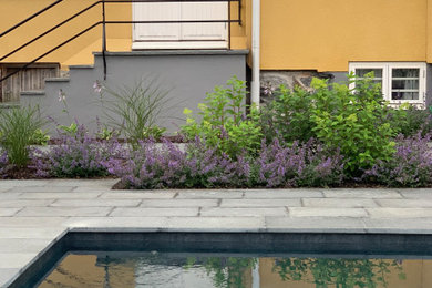 Mid-sized scandinavian backyard formal garden in Stockholm with with flowerbed and natural stone pavers for summer.