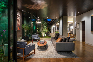Inspiration for a contemporary medium tone wood floor and brown floor living room remodel in Los Angeles with white walls