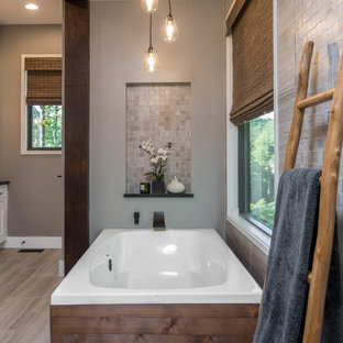 Cette photo montre une douche en alcôve principale montagne de taille moyenne avec un placard à porte shaker, des portes de placard blanches, une baignoire indépendante, un WC séparé, un carrelage beige, carrelage en mosaïque, un mur beige, un sol en carrelage de porcelaine, une grande vasque, un plan de toilette en stéatite, un sol beige et un plan de toilette noir.