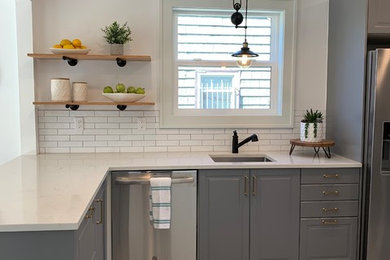 Example of a trendy kitchen design in Portland with an undermount sink, raised-panel cabinets, gray cabinets, quartz countertops and white countertops