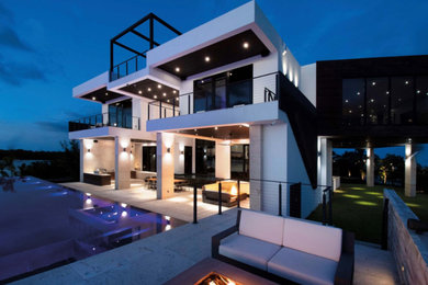 Large and white modern detached house in Houston with a flat roof and three floors.