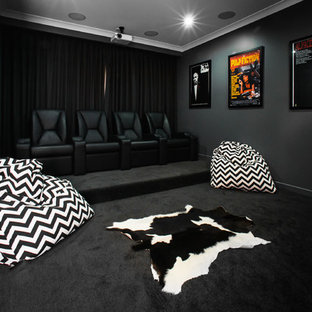 Idée de décoration pour une salle de cinéma design fermée avec un mur noir, moquette et un sol noir.