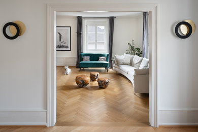 Ejemplo de salón abierto clásico con paredes blancas, suelo de madera en tonos medios y boiserie