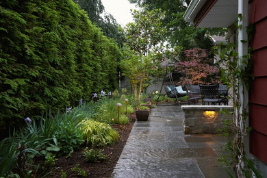 Inspiration for a mid-sized traditional side yard patio in New York with natural stone pavers and no cover.