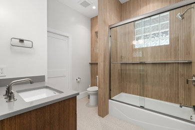 Inspiration for a mid-sized transitional brown tile and porcelain tile porcelain tile, beige floor and single-sink bathroom remodel in Tampa with shaker cabinets, medium tone wood cabinets, a one-piece toilet, white walls, an undermount sink, quartz countertops, gray countertops and a built-in vanity