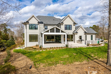 Inspiration for a beige two-story brick house exterior remodel in Raleigh with a shingle roof and a gray roof