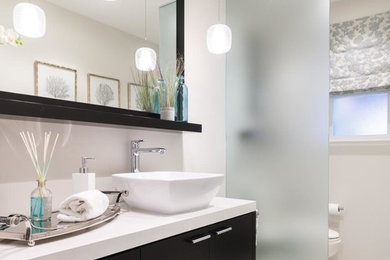 Example of a mid-sized trendy 3/4 white tile and stone slab porcelain tile and white floor open shower design in San Francisco with flat-panel cabinets, black cabinets, a two-piece toilet, gray walls, a vessel sink and solid surface countertops