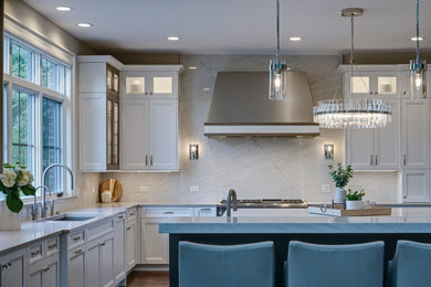 This is an example of an expansive transitional l-shaped eat-in kitchen in Chicago with an undermount sink, raised-panel cabinets, grey cabinets, quartzite benchtops, grey splashback, stone slab splashback, panelled appliances, dark hardwood floors, multiple islands, brown floor and grey benchtop.