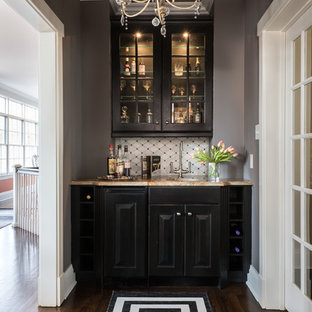 セントルイスの小さいトランジショナルスタイルのおしゃれなウェットバー (アンダーカウンターシンク、レイズドパネル扉のキャビネット、黒いキャビネット、御影石カウンター、茶色い床、濃色無垢フローリング、ベージュのキッチンカウンター) の写真