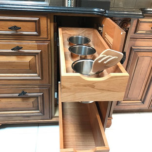 Inspiration pour une grande arrière-cuisine linéaire traditionnelle avec un placard avec porte à panneau surélevé, des portes de placard en bois vieilli, un plan de travail en granite, une crédence beige, une crédence en marbre, un électroménager en acier inoxydable, un sol en carrelage de porcelaine, un îlot central et un sol beige.