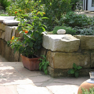 Kleine Terrasse mit Sitzmauer aus Naturstein