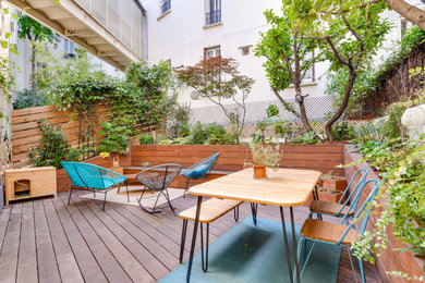 Idée de décoration pour une terrasse arrière et au rez-de-chaussée design de taille moyenne avec des solutions pour vis-à-vis et un garde-corps en bois.