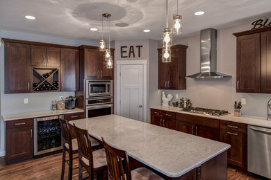Example of a large farmhouse u-shaped medium tone wood floor open concept kitchen design in Other with a double-bowl sink, shaker cabinets, dark wood cabinets, granite countertops, stainless steel appliances and an island