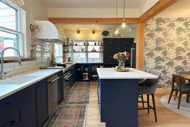 Eat-in kitchen - mid-sized transitional l-shaped light wood floor and beige floor eat-in kitchen idea in Portland with an undermount sink, recessed-panel cabinets, blue cabinets, quartz countertops, white backsplash, subway tile backsplash, stainless steel appliances, an island and white countertops