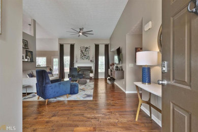 Living room - mid-sized contemporary open concept medium tone wood floor living room idea in Atlanta with gray walls and a wall-mounted tv
