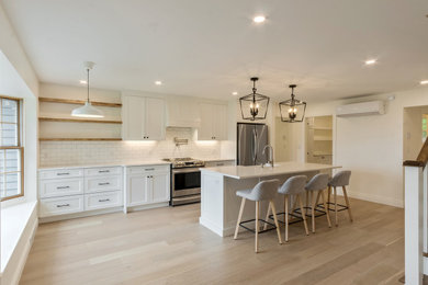 Kitchen - coastal light wood floor kitchen idea in Other with a farmhouse sink, shaker cabinets, white cabinets, quartz countertops, white backsplash and subway tile backsplash