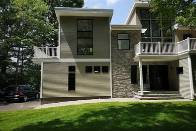 Foto de fachada de casa beige actual grande de dos plantas con revestimientos combinados y tejado plano