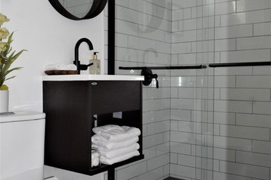 Small trendy 3/4 white tile and subway tile ceramic tile and multicolored floor bathroom photo in Los Angeles with flat-panel cabinets, black cabinets, a one-piece toilet, white walls and white countertops