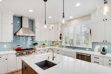 Farmhouse u-shaped light wood floor and beige floor kitchen photo in Denver with a farmhouse sink, shaker cabinets, white cabinets, quartz countertops, blue backsplash, glass tile backsplash, stainless steel appliances, an island and white countertops