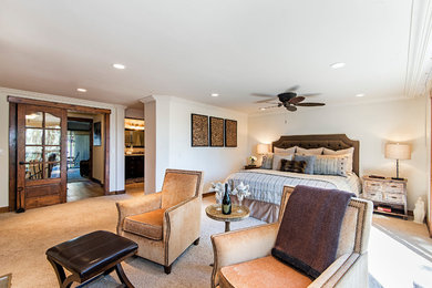 Inspiration for a large transitional master carpeted bedroom remodel in Other with beige walls, a standard fireplace and a stone fireplace