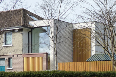 Ejemplo de fachada de casa bifamiliar rosa y marrón actual de tamaño medio de dos plantas con revestimiento de madera, tejado plano, tejado de teja de barro y panel y listón