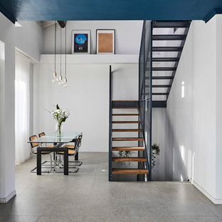 Idées déco pour une grande salle à manger ouverte sur le salon contemporaine avec un mur blanc, une cheminée double-face, un manteau de cheminée en carrelage, un sol gris et un sol en carrelage de porcelaine.