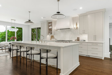 Eat-in kitchen - large traditional single-wall dark wood floor and brown floor eat-in kitchen idea in Charlotte with an undermount sink, shaker cabinets, white cabinets, marble countertops, white backsplash, stainless steel appliances and an island