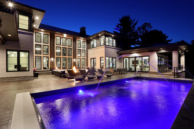 Example of a minimalist backyard rectangular aboveground pool fountain design in Grand Rapids